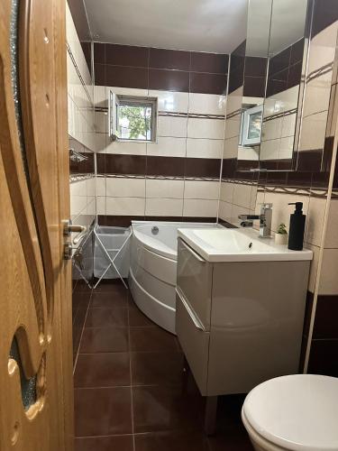 a bathroom with a toilet and a tub and a sink at Cozyhouse in Drobeta-Turnu Severin