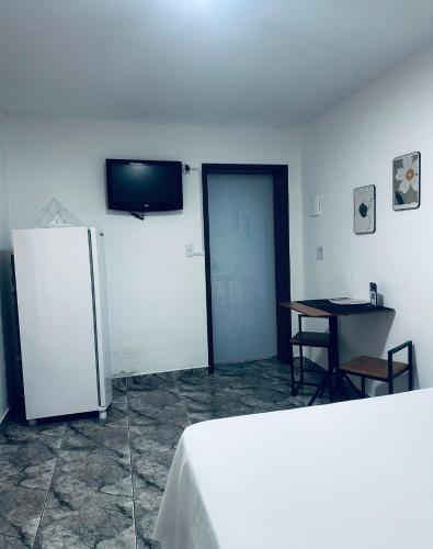 a white room with a table and a refrigerator at FRAN's - HOSPEDAGENS in Lagoa Santa