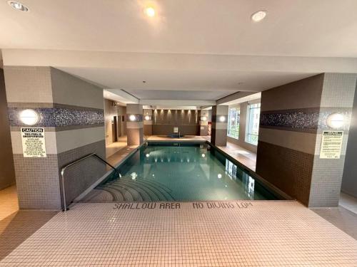 a swimming pool in a building with ailed floor at Large Downtown 2Br condo with Parking steps to Eaton Centre, UofT and SickKids in Toronto