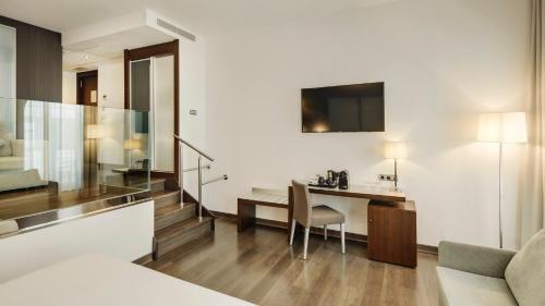 a living room with a desk and a chair at Sercotel Coliseo in Bilbao