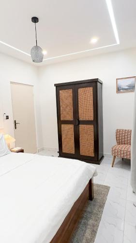 a white room with a bed and a chair at La brise Marine in Lomé