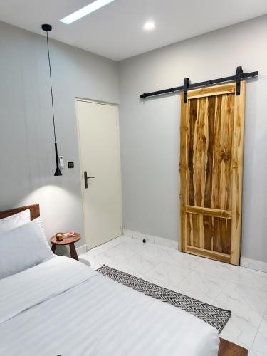 a bedroom with a bed and a wooden door at La brise Marine in Lomé
