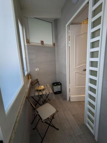 a hallway with a table and a chair and a door at Al GeChiGiù in Bacoli