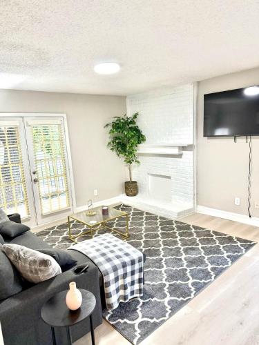 a living room with a couch and a flat screen tv at Cozy retreat 1Br 1Ba near hospital and tollway in Addison