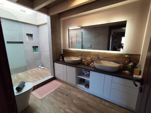 a bathroom with two sinks and a large mirror at Schinias beach villa in Schinias