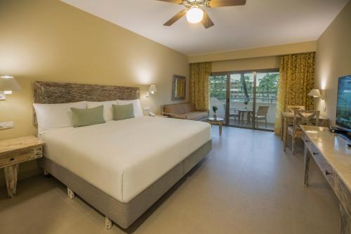 sypialnia z dużym łóżkiem i salonem w obiekcie Iberostar Waves Dominicana - All Inclusive w Punta Cana