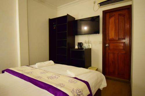 a bedroom with a bed and a wooden door at Arianna Dhangethi in Dhangethi