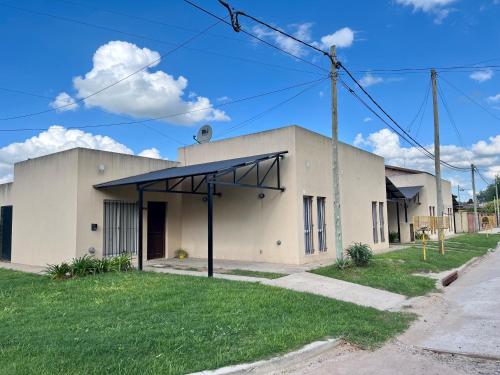 a white building with a black roof at Las Lilas in Roque Pérez