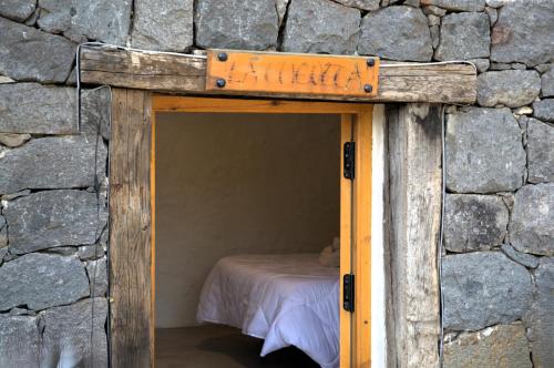 a small room with a bed in a stone wall at El Refugio de Las Vegas in Valsequillo
