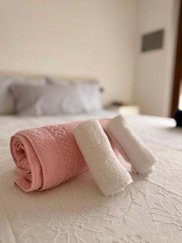 a pink towel sitting on top of a bed at Helena home in Torre De' Roveri