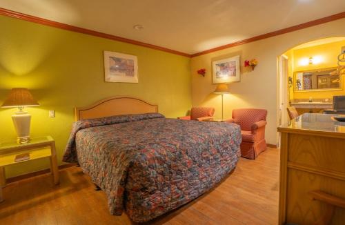 a hotel room with a bed and a sink at Sunstar Inn in Los Banos