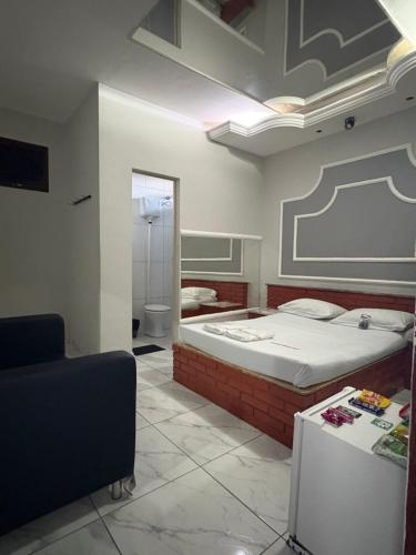 ein Schlafzimmer mit einem großen Bett und einem Spiegel in der Unterkunft Motel Fascinação in Contagem