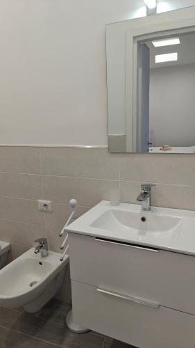 a bathroom with a sink and a toilet and a mirror at Swallow Room Holidays in Massa Lubrense