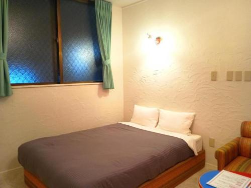 a bedroom with a bed and a window and a chair at Hotel PUTIT BELL - Vacation STAY 57162v in Takahara