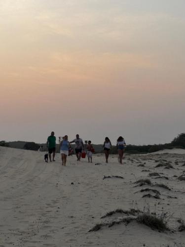 a group of people walking on the beach at Casa de Veraneio in Caucaia