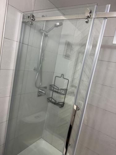 a shower with a glass door in a bathroom at Sand Pebbles Inn in Qualicum Beach