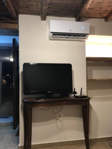 a flat screen tv sitting on a table next to a wall at Aristos Cottage in Káto Lekhónia