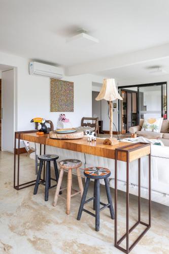 a kitchen with a table and stools in a room at Vaca do Brejo, piscina aquecida, sauna, A/C quente in Petrópolis