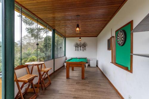 a room with a pool table and some windows at Vaca do Brejo, piscina aquecida, sauna, A/C quente in Petrópolis