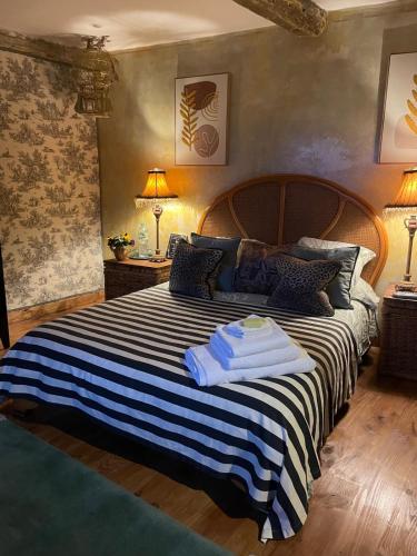 une chambre avec un grand lit avec deux serviettes dessus dans l'établissement Le Presbytere, à Castex