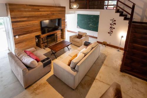 a living room with two couches and a flat screen tv at Vaca do Brejo, piscina aquecida, sauna, A/C quente in Petrópolis