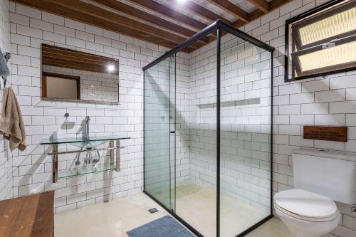a glass shower in a bathroom with a toilet at Vaca do Brejo, piscina aquecida, sauna, A/C quente in Petrópolis