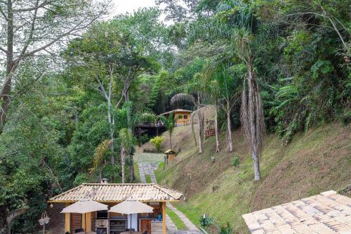 a resort with a house on a hill with trees at Vaca do Brejo, piscina aquecida, sauna, A/C quente in Petrópolis