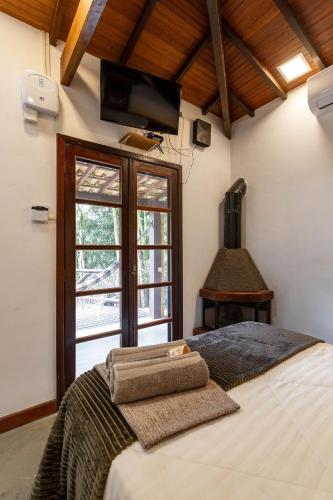 a bedroom with a bed and a window and a piano at Vaca do Brejo, piscina aquecida, sauna, A/C quente in Petrópolis