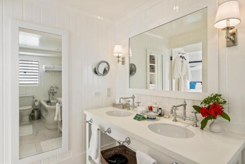 a bathroom with two sinks and a large mirror at Round Hill Hotel & Villas in Montego Bay