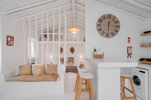 a white kitchen with a clock on the wall at Abrigo da Sorna in São Marcos do Campo