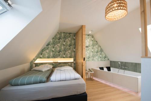 a bedroom with a bed and a sink and a tub at L'Exotique Baignoire Double Cozy Duplex in Haguenau