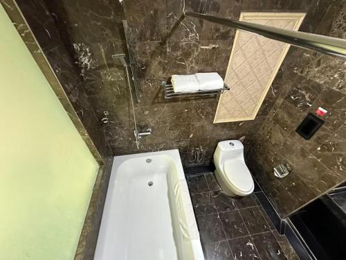 a bathroom with a tub and a toilet in it at Suasana Hotel Chukai in Cukai