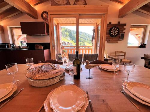 - une table à manger avec une bouteille de vin et des verres dans l'établissement Résidence Ambrocella - Appartement de charme sous les toits MAE-2301, aux Gets