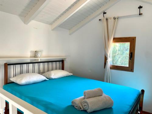 a bedroom with a blue bed with towels on it at Hidden Gem at Kiani Beach in Kalyves