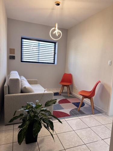 a living room with a couch and a red chair at Duplex Central TAVARES ARAUJO in Garanhuns