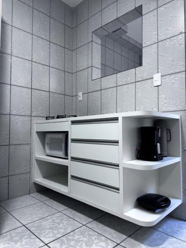 a kitchen with a white cabinet with a microwave at Duplex Central TAVARES ARAUJO in Garanhuns