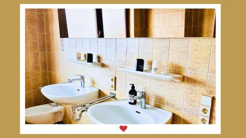 a bathroom with two sinks and a toilet at Berghupferl-Alm - do legst di nieda in Flintsbach am Inn
