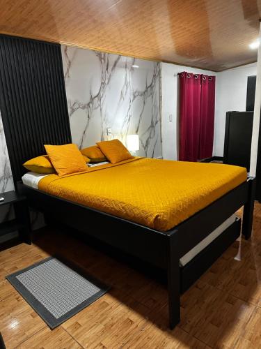 a bedroom with a bed with yellow pillows at Caribbean View in Tortuguero