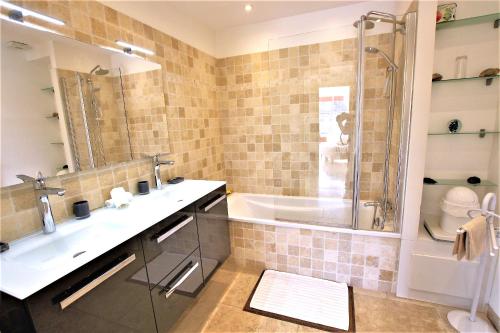 a bathroom with a tub and a sink and a shower at Fully equipped appartment 105 m2 clear view on the sea and californie hills in Cannes