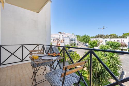 a balcony with a table and chairs and a view of a city at Elegant Flat with Pool & Balcony by HostWise in Tavira