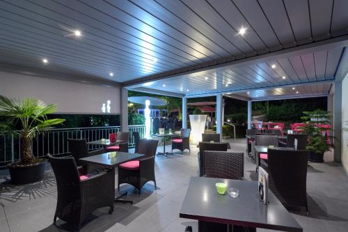 un restaurant avec des tables et des chaises sur une terrasse dans l'établissement Hôtel Bellevue, à Porrentruy