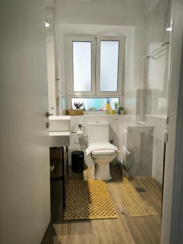 a bathroom with a white toilet and a window at Deppy's House in Vasiliki
