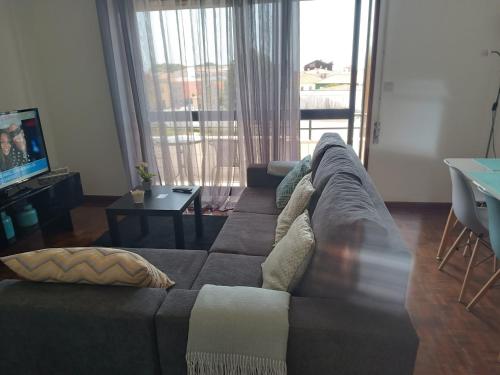 a living room with a couch and a television at Apartamento Solzende in Esposende