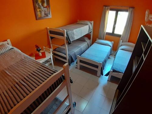 a room with three bunk beds and a window at Posada trinidad in Pinamar