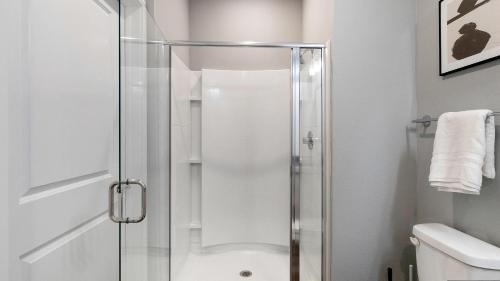 a shower with a glass door in a bathroom at Landing at FarmHaus - Huntsville in Madison