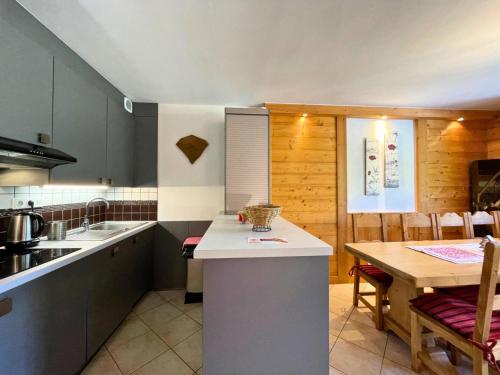 une cuisine avec une table et un comptoir dans l'établissement Résidence Courmayeur - Appartement 8/10 personnes 81m² aux Menuires MAE-4334, aux Menuires