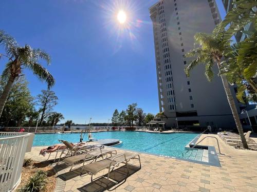 a swimming pool with lounge chairs and a building at Lake Views At Blue Heron in Orlando
