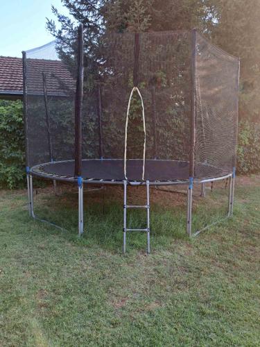 a trampoline with a net on the grass at Infinity by the River in Kumanovo