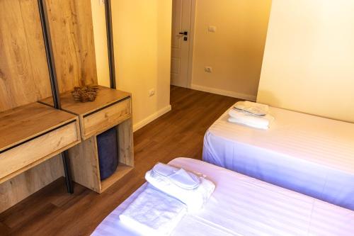 two beds in a room with wooden floors at Sofra Kelmendit in Tamarë