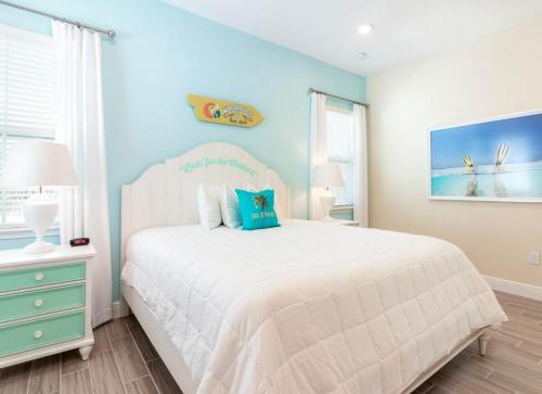 a bedroom with a white bed and a blue wall at Parrotfish Place - Stay for 6 in Orlando
